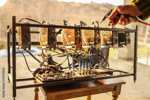 Man cleaning dust from cryptocurrency mining rig with air compressor