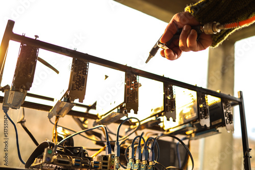Man cleaning dust from cryptocurrency mining rig with air compressor