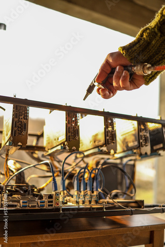 Man cleaning dust from cryptocurrency mining rig with air compressor