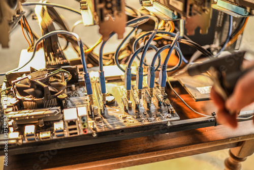 Man cleaning dust from cryptocurrency mining rig with air compressor