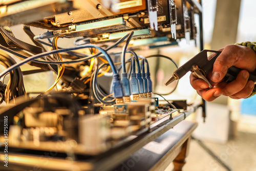 Man cleaning dust from cryptocurrency mining rig with air compressor