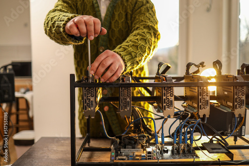 Man using screwdriver for setting up cryptocurrency mining rig at home