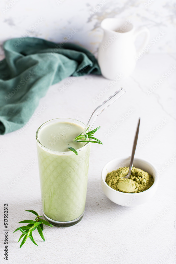 Ice whipped matcha latte with milk in a glass and powder in a bowl. Homemade drink. Vertical view Ice whipped matcha latte with milk in a glass and powder in a bowl. Homemade drink. Vertical view