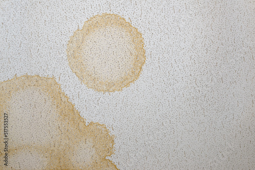 Looking directly up at a dirty stained ceiling tile. Stained were made by water leaking from above.