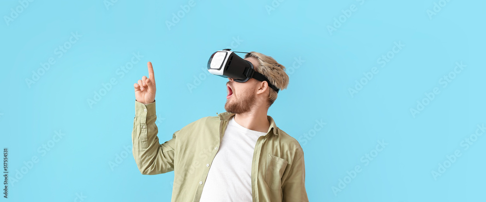 Young man with VR glasses on light blue background Young man with VR glasses on light blue background