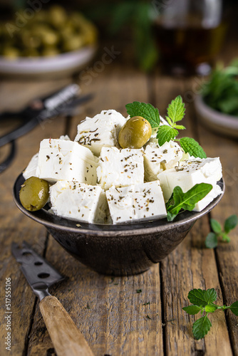 Greek cheese feta in bowl with olives and mint on wooden background