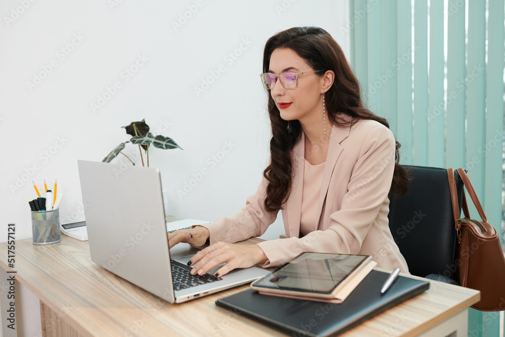 Smiling elegant human resources manager working on laptop at home Smiling elegant human resources manager working on laptop at home