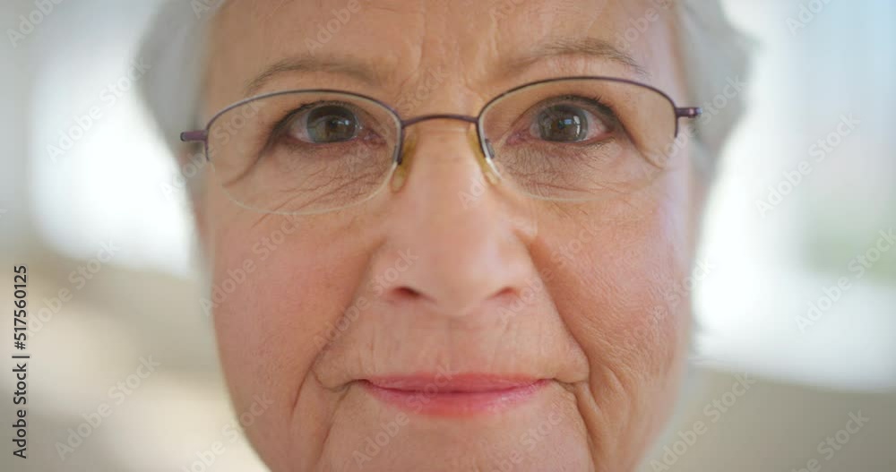 Closeup face of a senior womans eyes with glasses to improve her vision. Portrait of an elderly lady with spectacles to help with eyesight or nearsightedness. Older woman with a positive attitude Closeup face of a senior womans eyes with glasses to improve her vision. Portrait of an elderly lady with spectacles to help with eyesight or nearsightedness. Older woman with a positive attitude