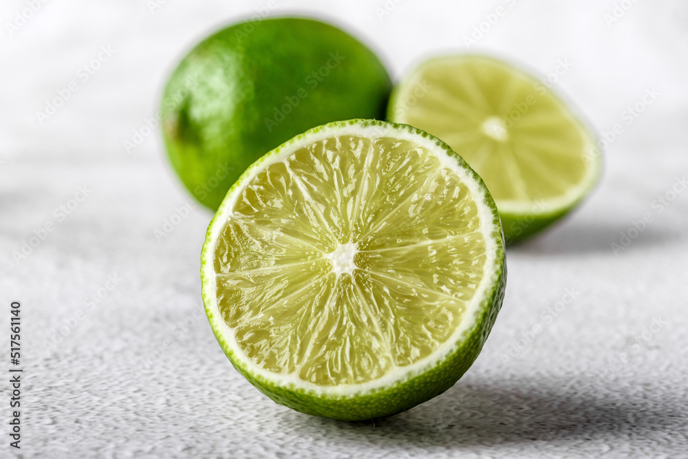Green lime with cut in half and slices isolated on white background.Healthy green foods - alternative medicine involve a balanced diet with vitamins, nutritions and superfoods for human well-being. Green lime with cut in half and slices isolated on white background.Healthy green foods - alternative medicine involve a balanced diet with vitamins, nutritions and superfoods for human well-being.