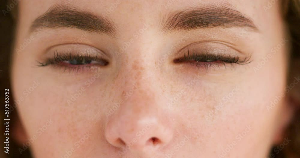 Closeup face of a young emotional woman with tears in her eyes. Portrait of a sad female crying with pain and hurt in her eyeballs. A tired lady tearing up with a bit of redness due to allergies