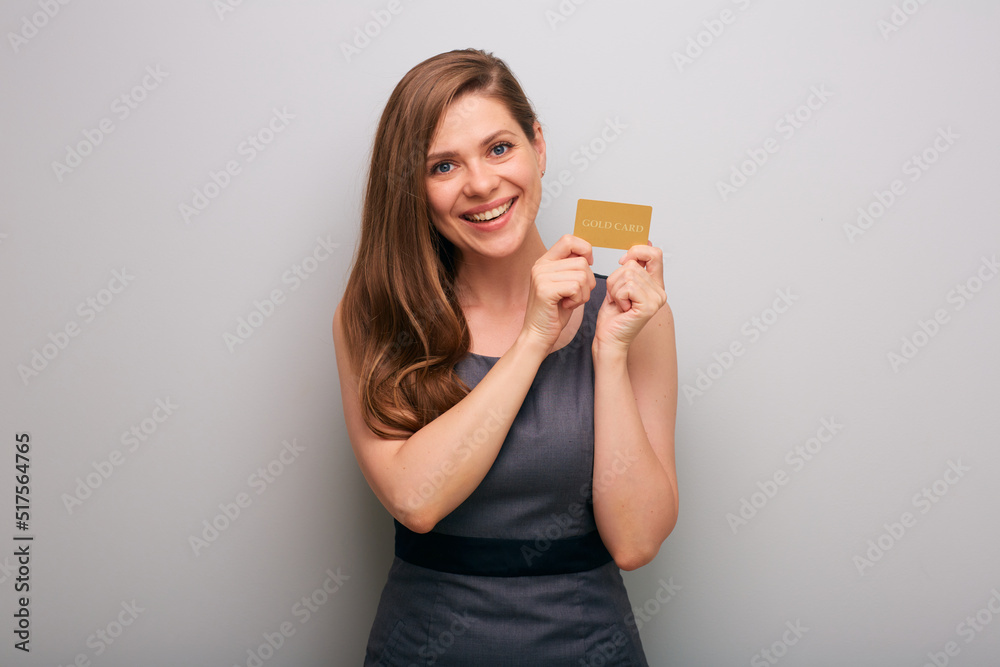 Smiling business woman in gray dress holding gold card for credit. isolated female business person portrait. Smiling business woman in gray dress holding gold card for credit. isolated female business person portrait.