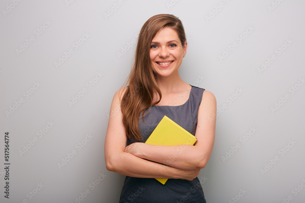 Smiling business woman in gray dress holding yellow book. isolated female business person portrait. Smiling business woman in gray dress holding yellow book. isolated female business person portrait.