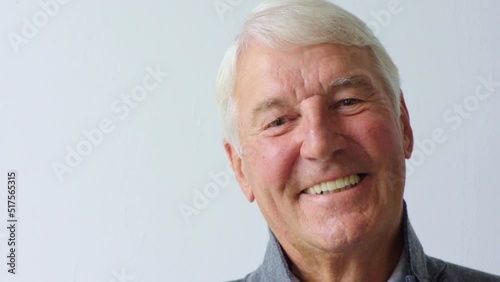 Closeup headshot and face of one senior, carefree and cheerful man giggling at a funny joke. Portrait of a laughing mature confident man isolated against a grey background in studio with copy space