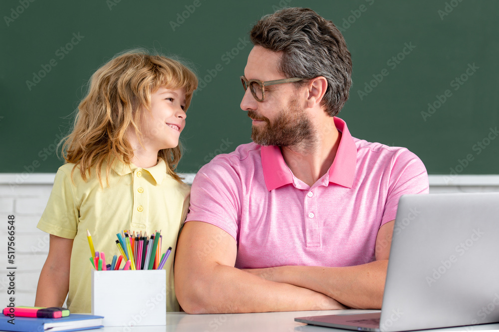 Elementary school boy in classroom on lesson. Teacher explaining to pupil. First day at school. Cute little boy studying lesson in class. Elementary school boy in classroom on lesson. Teacher explaining to pupil. First day at school. Cute little boy studying lesson in class.