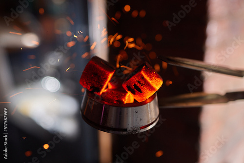 Burning red coals for hookah during preparation. photo