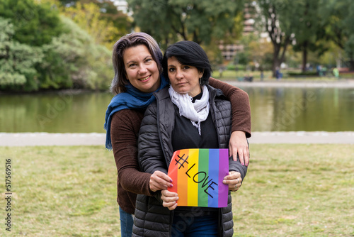Love. Cheerful queer couple holding a message supporting the LGBT community photo