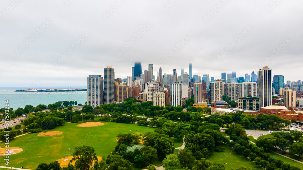 Fototapeta premium establishing aerial drone footage of a Chicago neighborhood downtown. the city beautiful architectural is also covered by lush green trees throughout creating a welcoming view for tourist