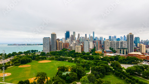 establishing aerial drone footage of a Chicago neighborhood downtown. the city beautiful architectural is also covered by lush green trees throughout creating a welcoming view for tourist