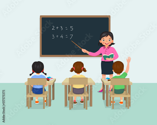 Young female teacher teaching math lesson to students in the classroom 