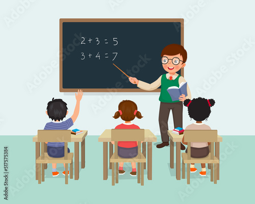 Young male teacher teaching math lesson to students in the classroom 