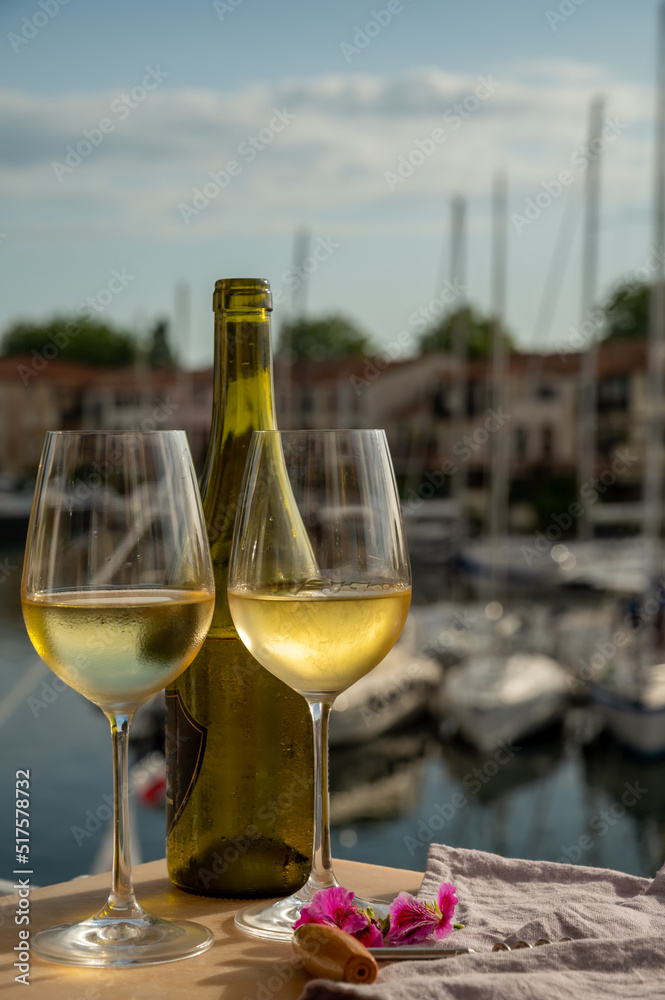 Drinking of cold white wine  with view on yacht harbour of Port Grimaud, summer vacation on French Riviera, France