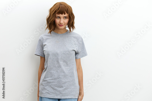 horizontal studio photo on a white background of a cute, pleasant, tanned woman in a gray cotton T-shirt