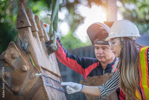 Portrait of a beautiful Asian engineer holding a wrench The background is a container, concept of engineer or an industrial mechanic.