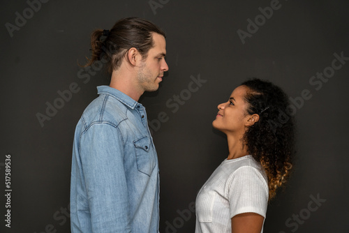 Romantic young happy couple caucasian man and african american woman smile and have fun together in valentine day on black background