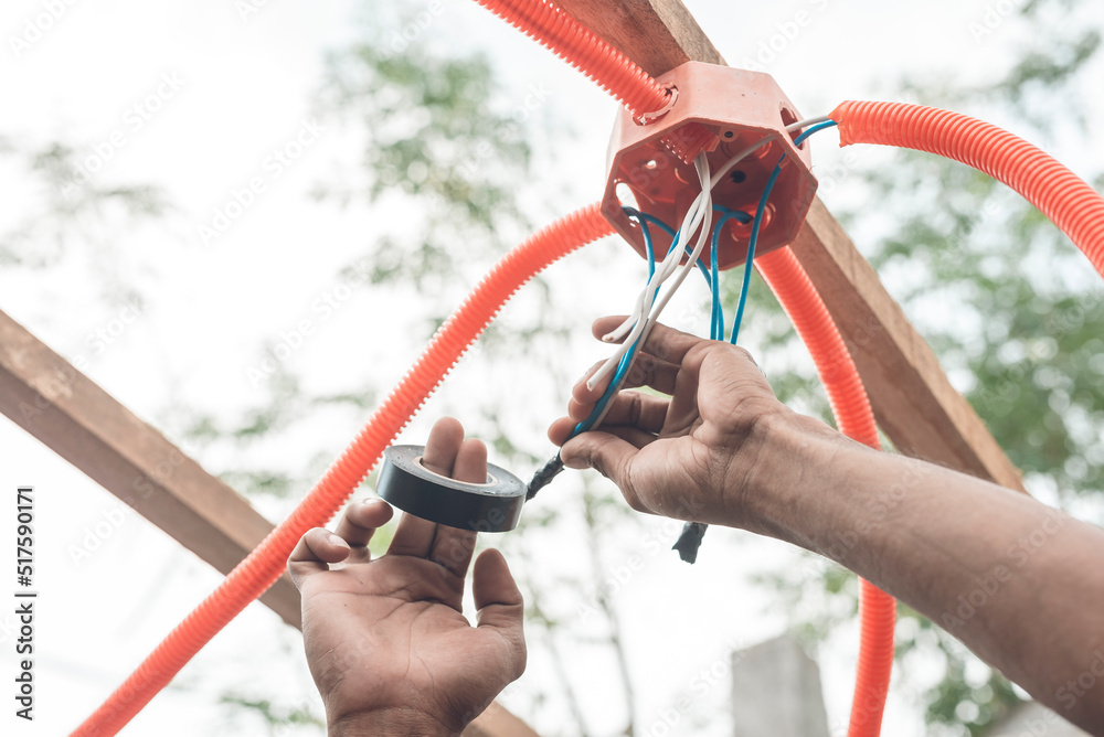 Using electric tape to cover exposed wiring from the elements. Wires jutting out from a plastic