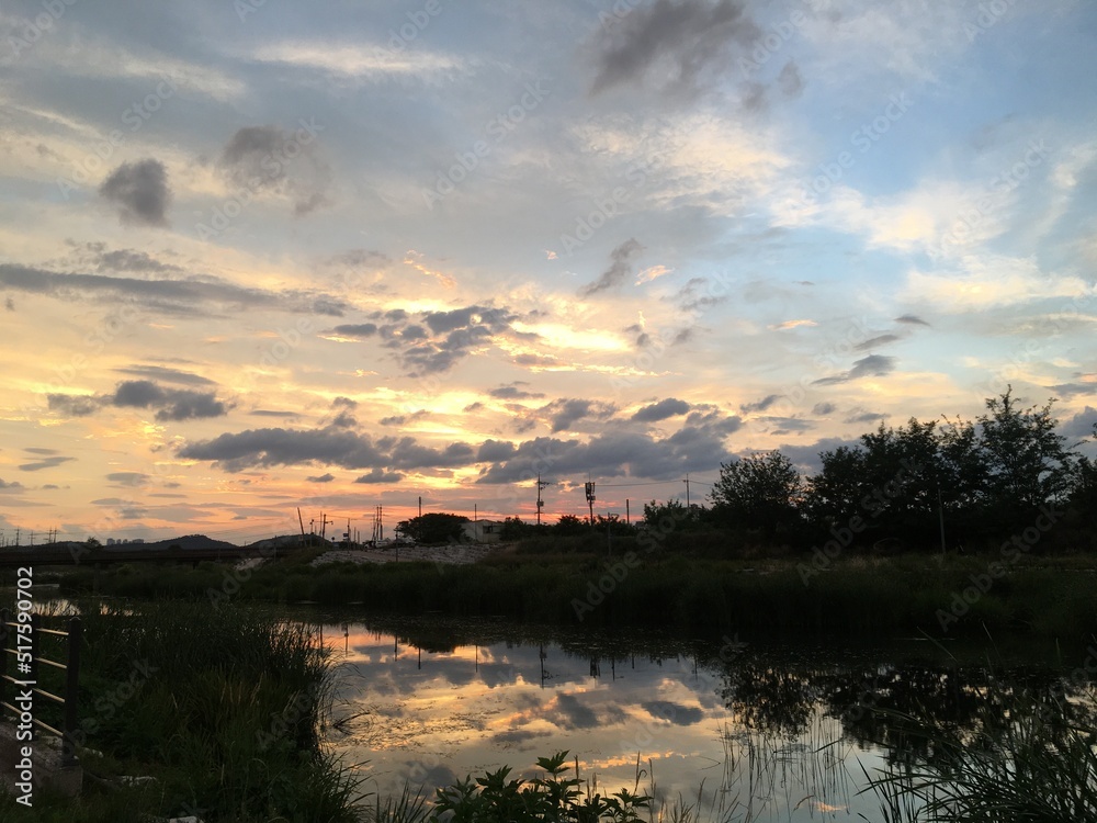 Obraz premium Beautiful sky with clouds and river at sunset. 