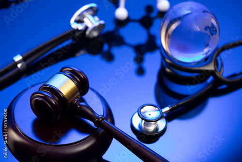 Medical law concept. Gavel  legal code and stethoscope on the glass table. Blue light.