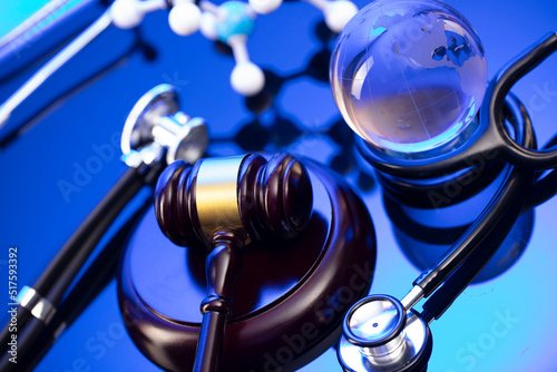 Medical law concept. Gavel  legal code and stethoscope on the glass table. Blue light.