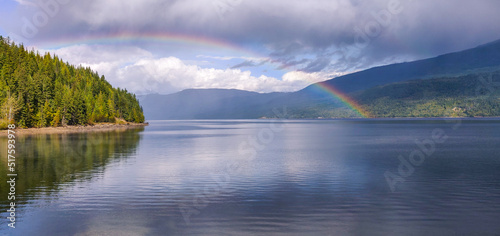 Rainbow over Adams Lake after a downpour, sun, lake reflection, cedar forest