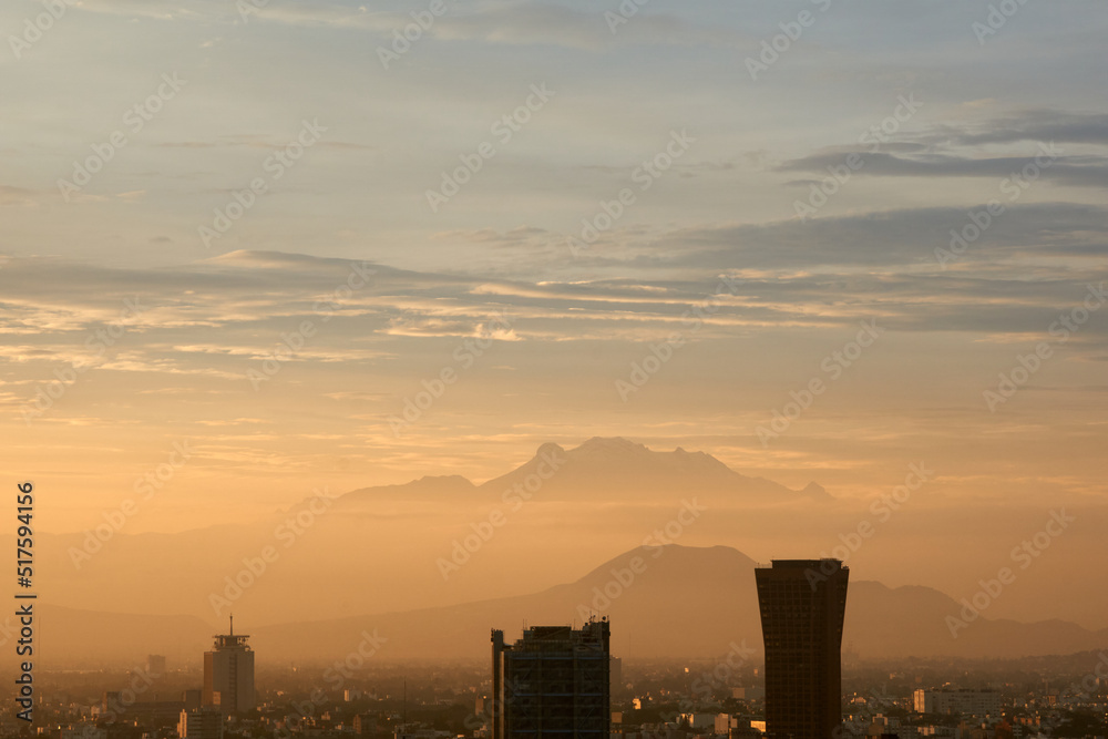 panoramic photo of a beautiful sunrise in mexico city with volcanos in the background (Iztaccíhuatl,  popocatepetl).