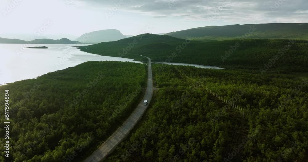 Aerial view following a Camper van driving in boreal wilderness, summer in Kilpisjarvi, Finland - tilt, drone shot Aerial view following a Camper van driving in boreal wilderness, summer in Kilpisjarvi, Finland - tilt, drone shot