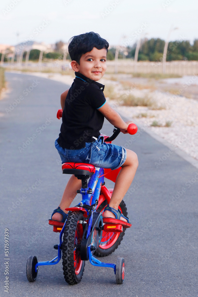 cute indian toddler riding a bicycle with smile cute indian toddler riding a bicycle with smile