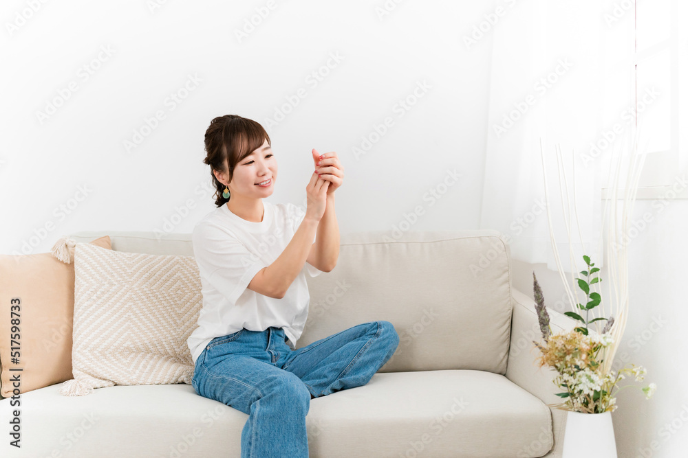手にハンドクリームを塗る日本人女性（スキンケア）
