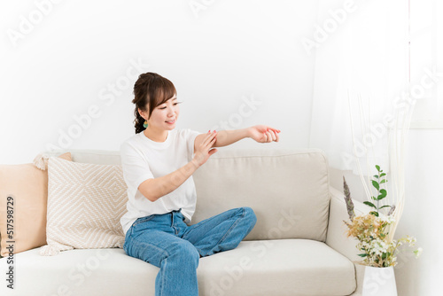 手にハンドクリームを塗る日本人女性（スキンケア） 