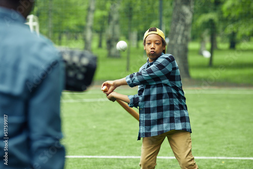 Photography African boy learning to hit the ball with bat during game in baseball together w