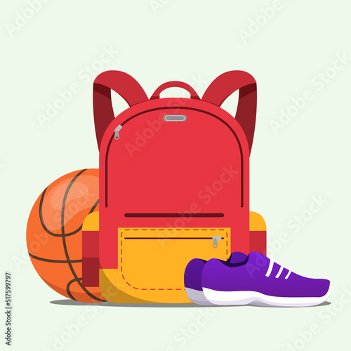 Red school bag with basketball and a pair of sport shoes isolated on a white background
