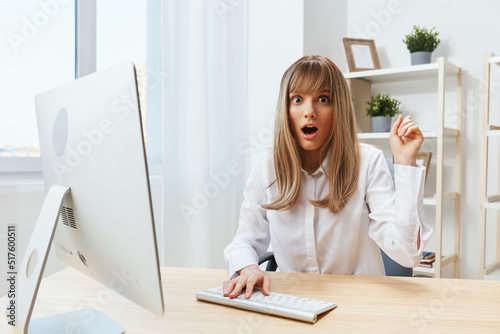 Shocked excited pretty blonde businesswoman freelancer look at camera open mouth point finger up have insight in light modern office. Employee work on computer online making decision. Copy space