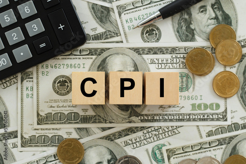 CPI, consumer price index symbol. Wooden blocks with words CPI, consumer price index on dollar bills with a calculator, coins.  Business and CPI, Business and consumer price index concept. photo