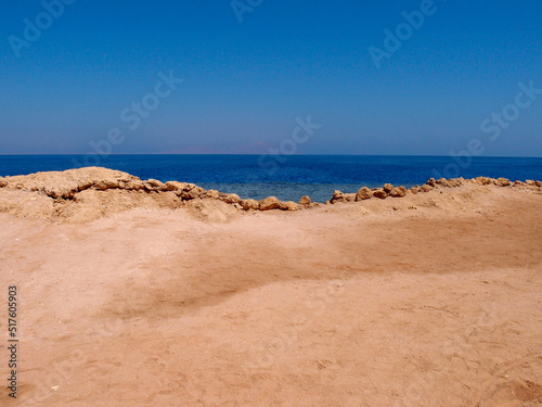 Beautiful view of the sea from a sandy beach with a rocky shore 