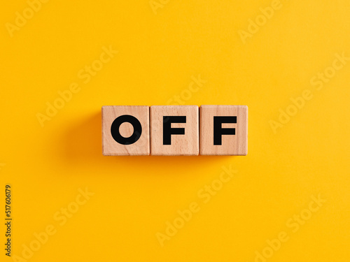 The word off on wooden cubes on yellow background.