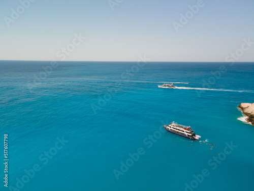 aerial view of porto katsiki beach with cruise boat people having fun © phpetrunina14