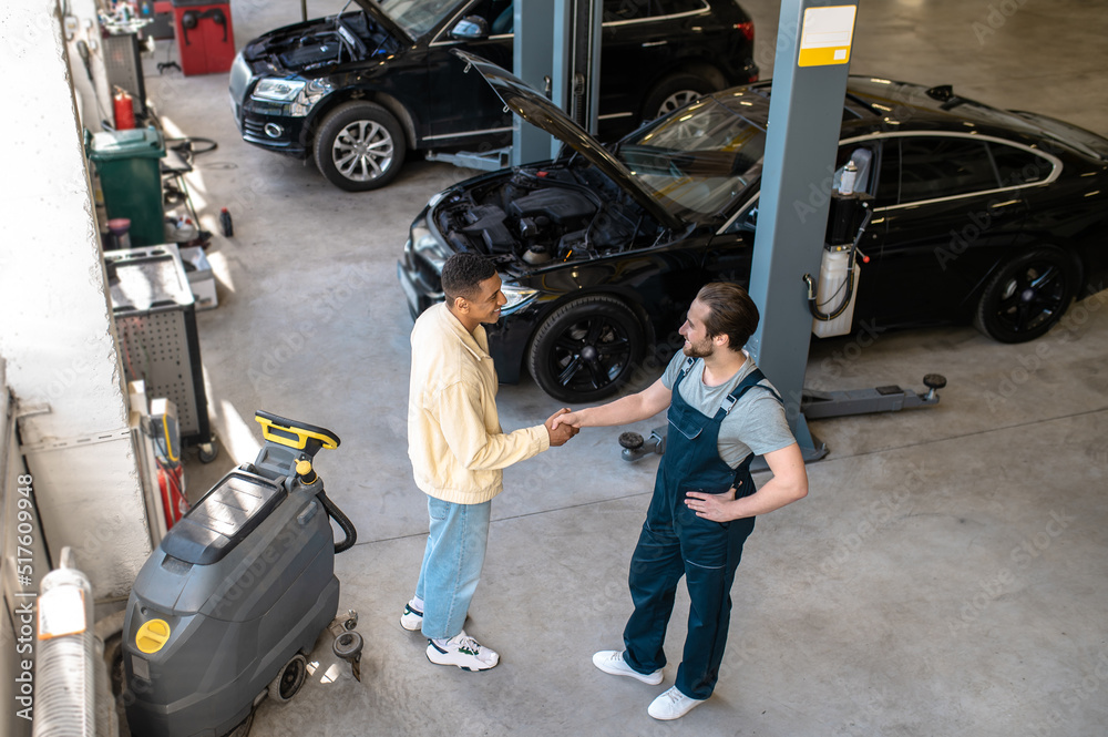 Fototapeta premium Maintenance engineer talking to the client in the garage
