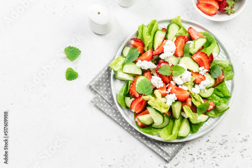 Strawberry cucumber feta cheese salad with balsamic dressing. Top view, copy space, flat lay.