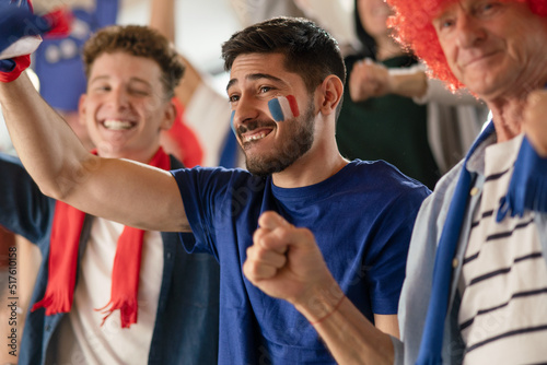 Φωτογραφία Excited football fans supporting French national team in live soccer match at stadium