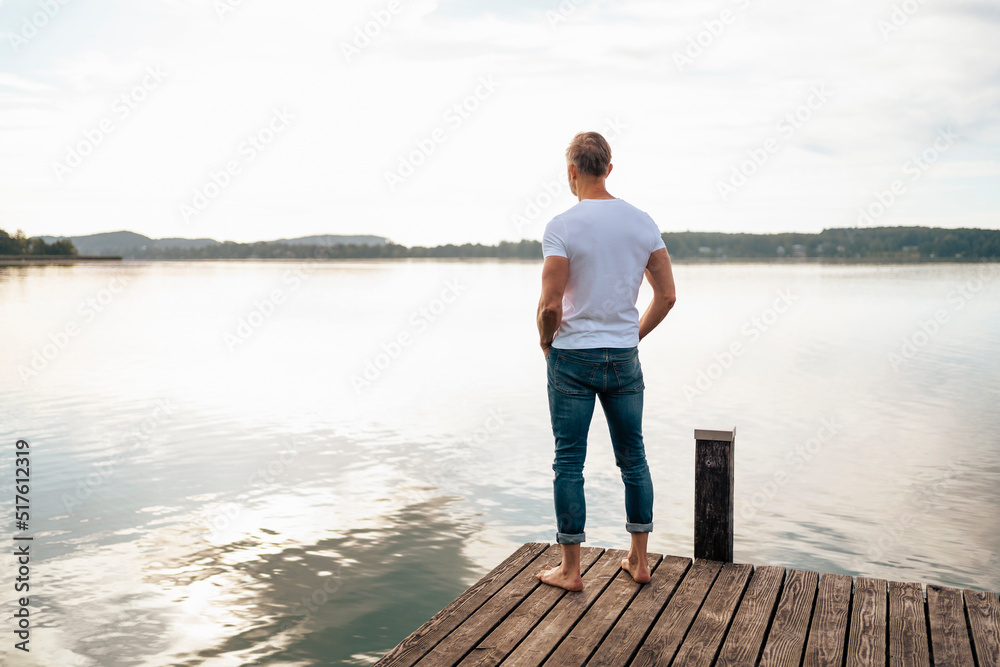 Man looking at view from pier over lake