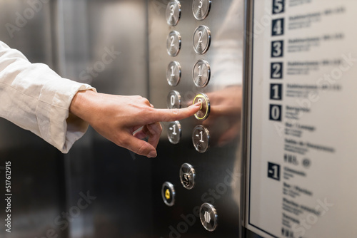 Hand of businesswoman pressing elevator button
